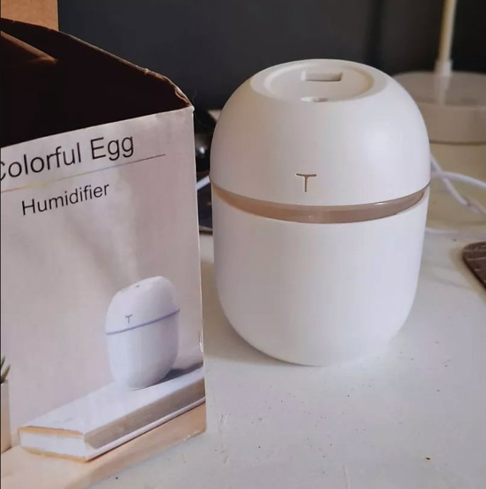 mini umidificador branco ao lado de caixa